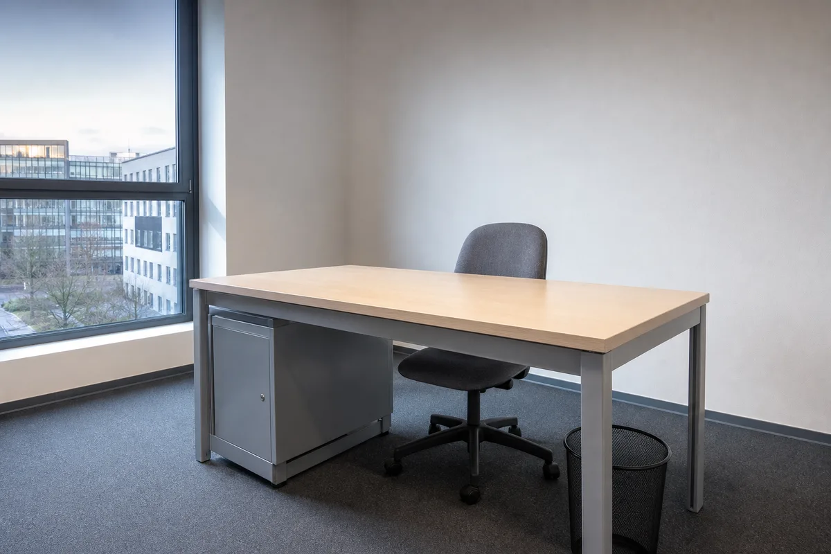 Poste de travail vide avec chaise de bureau et casier métallique fermé dans un bureau clair
