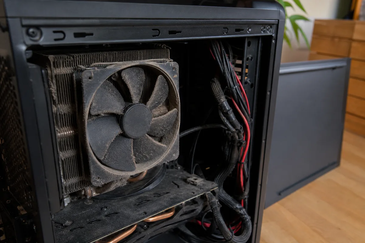 Intérieur d&rsquo;un boîtier d&rsquo;ordinateur fixe ouvert, ventilateur et radiateur empoussiérés